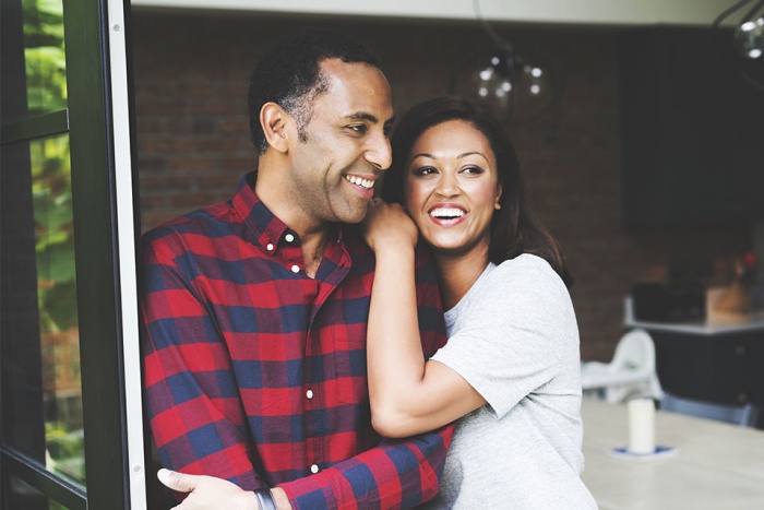 woman leaning on mans shoulder while looking outside