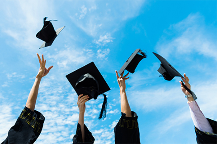 Graduates throwing their caps into the air.