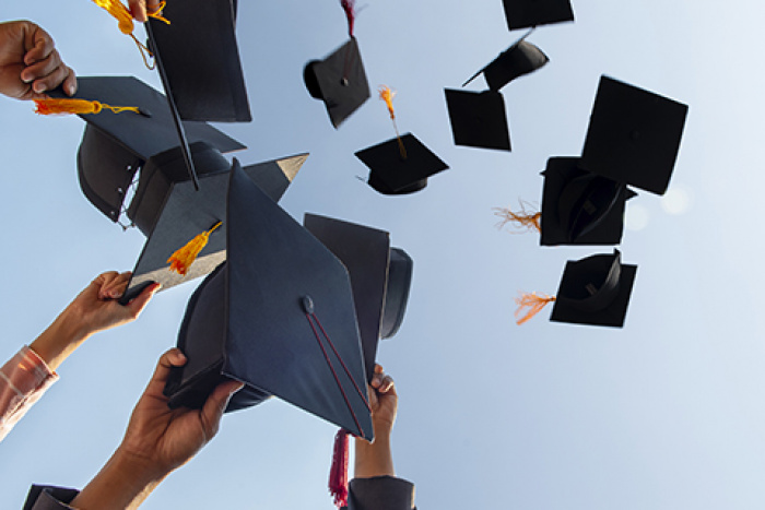 graduation caps thrown in the air