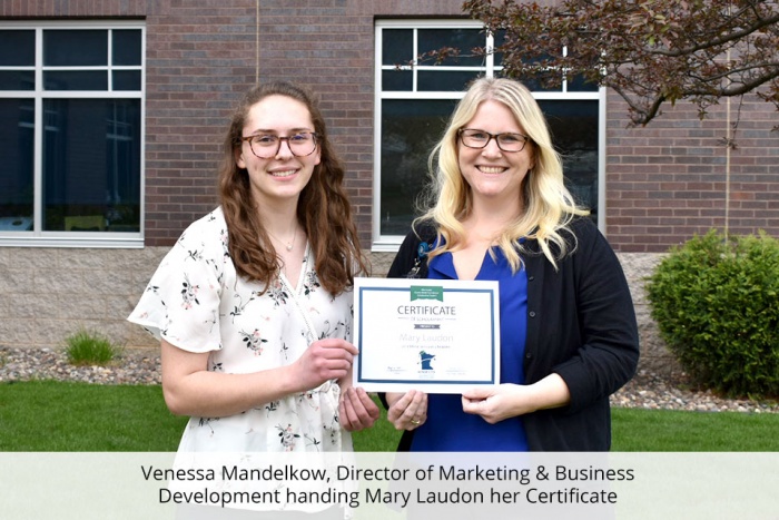 venessa mandelkow handing mary laudon her scholarship winning certificate