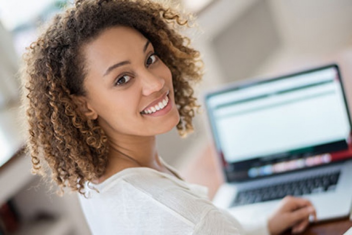 woman on laptop looking at camera