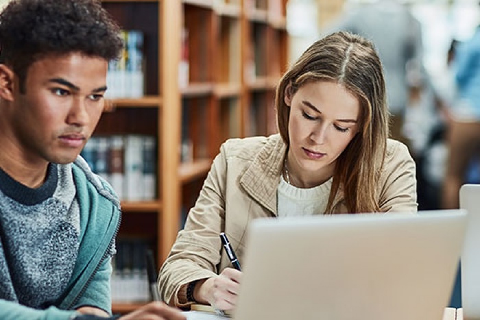 young man and woman studying in library